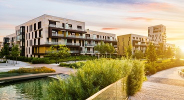 Immobilien mit einem Fluss und Büschen davor